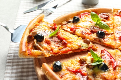 Photo of Slice of tasty pizza with olives and sausages on shovel, closeup