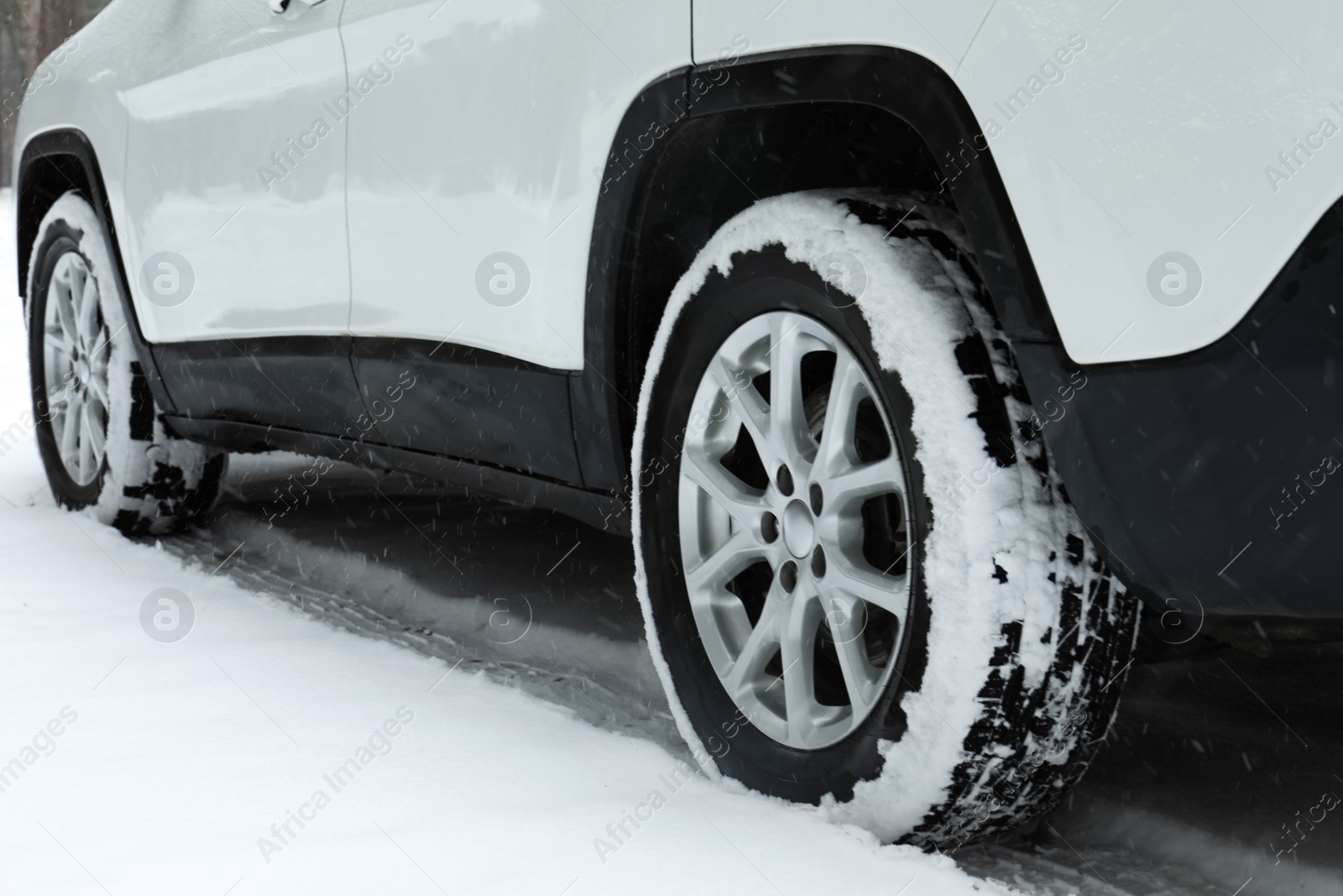 Photo of Modern car on snowy road, closeup view. Winter season