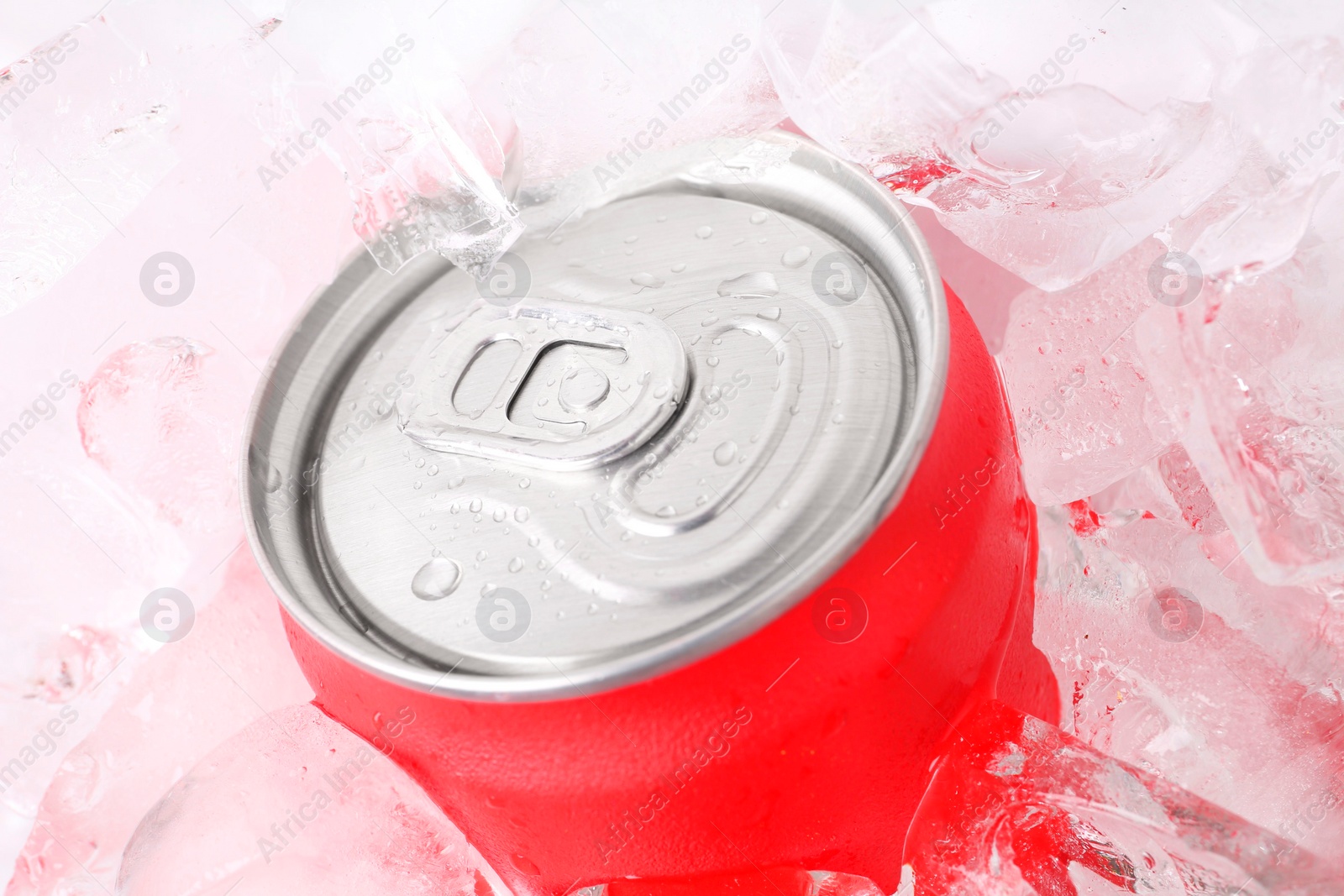 Photo of Energy drink in wet can and ice cubes, closeup