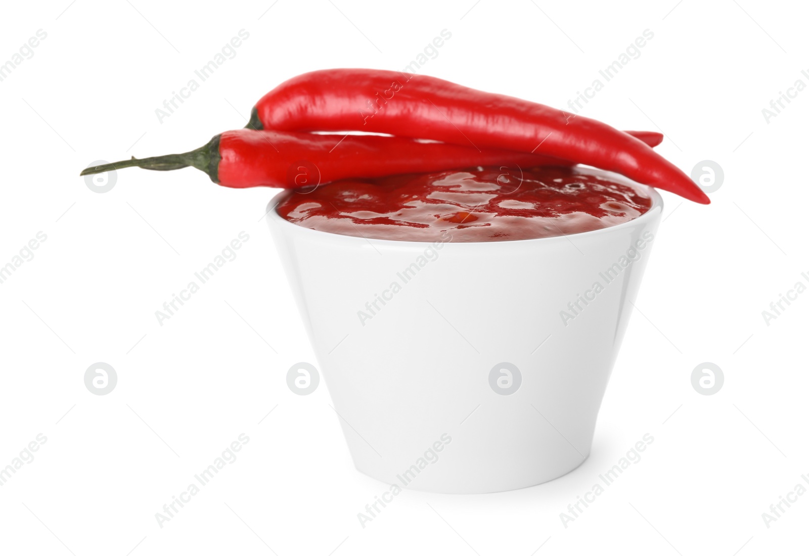 Photo of Bowl with red sauce and fresh chili peppers isolated on white