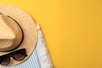 Flat lay composition with beach accessories on yellow background, space for text