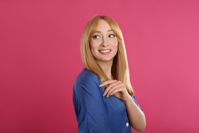 Photo of Beautiful young woman with blonde hair on pink background