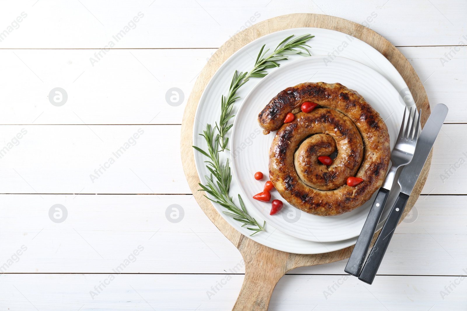 Photo of Tasty homemade sausages served on white wooden table, top view. Space for text