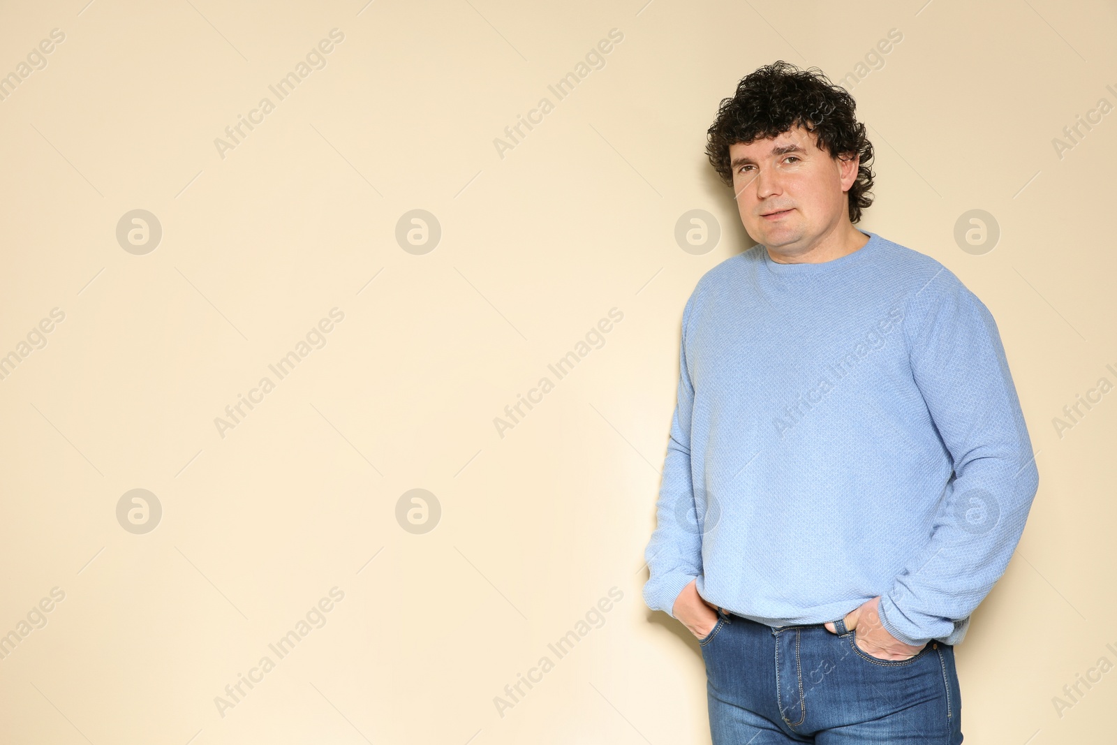 Photo of Portrait of handsome mature man posing on color background. Space for text