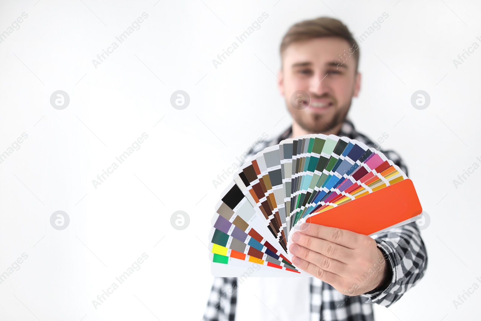 Photo of Young man with color palette on white background