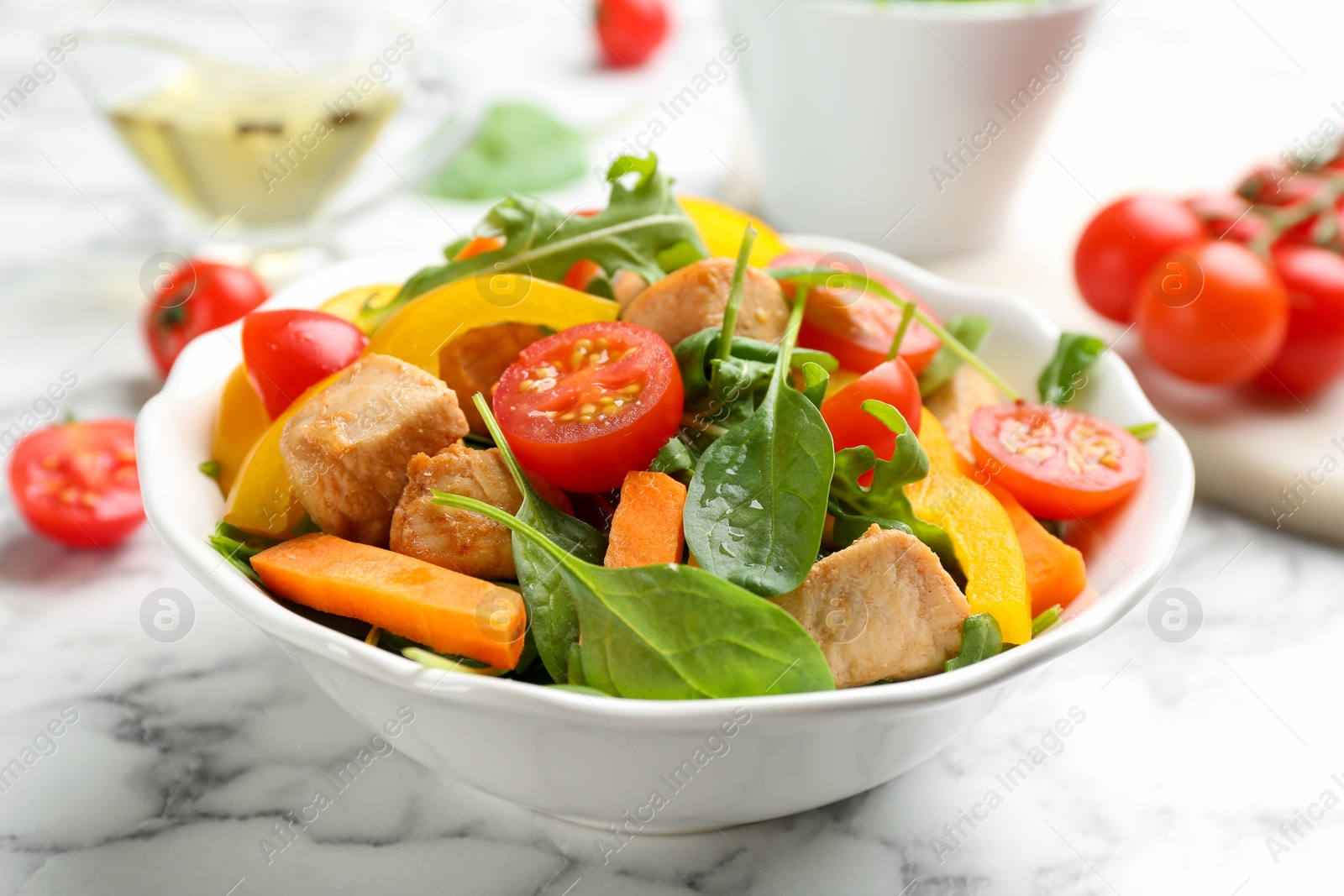 Photo of Delicious fresh chicken salad served on white marble table, closeup