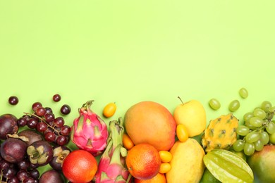 Photo of Many different delicious exotic fruits on green background, flat lay. Space for text