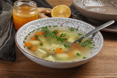 Bowl of fresh homemade soup to cure flu on wooden table