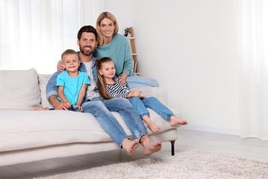 Photo of Portrait of happy family with children on sofa at home, space for text