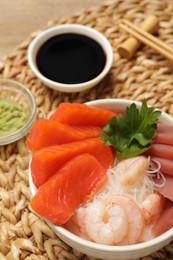 Photo of Delicious sashimi set of salmon, shrimps and tuna served with funchosa and parsley on table, closeup