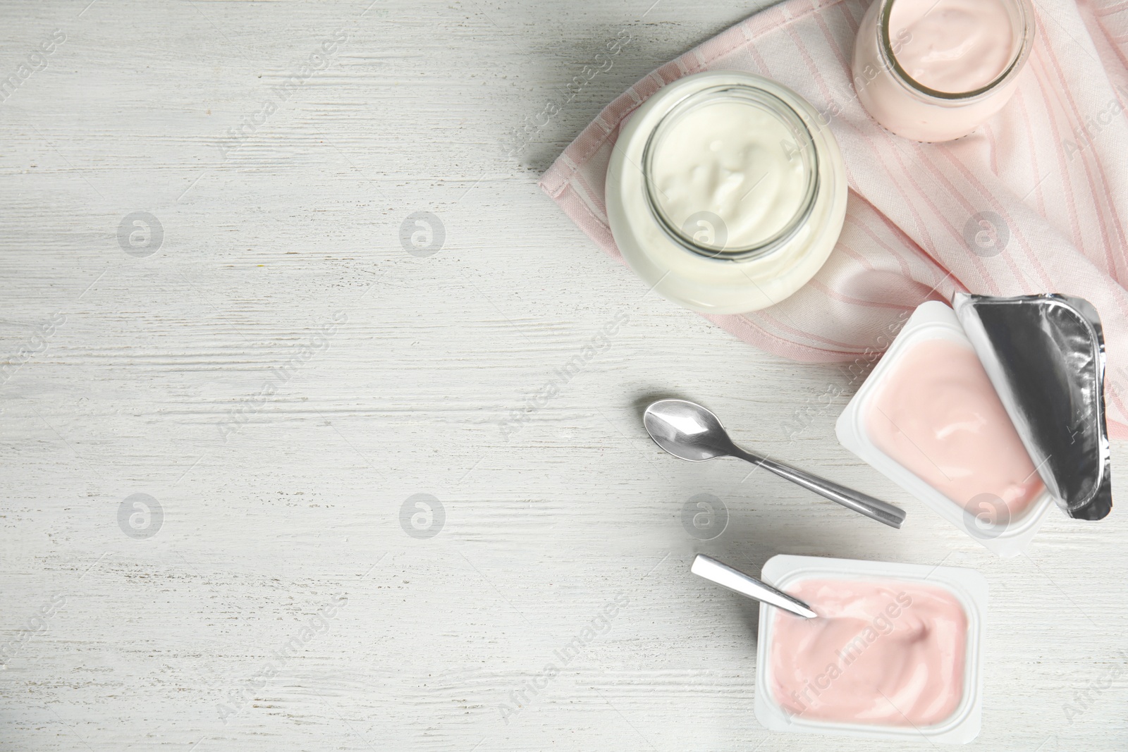 Photo of Tasty organic yogurt on white wooden table, flat lay. Space for text