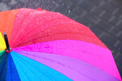 Photo of Bright color umbrella under rain outdoors, closeup