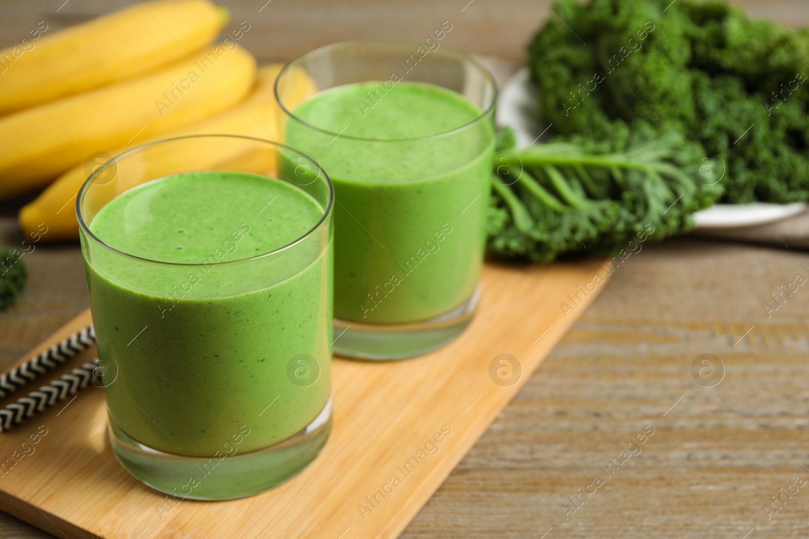 Photo of Tasty fresh kale smoothie on wooden table, closeup