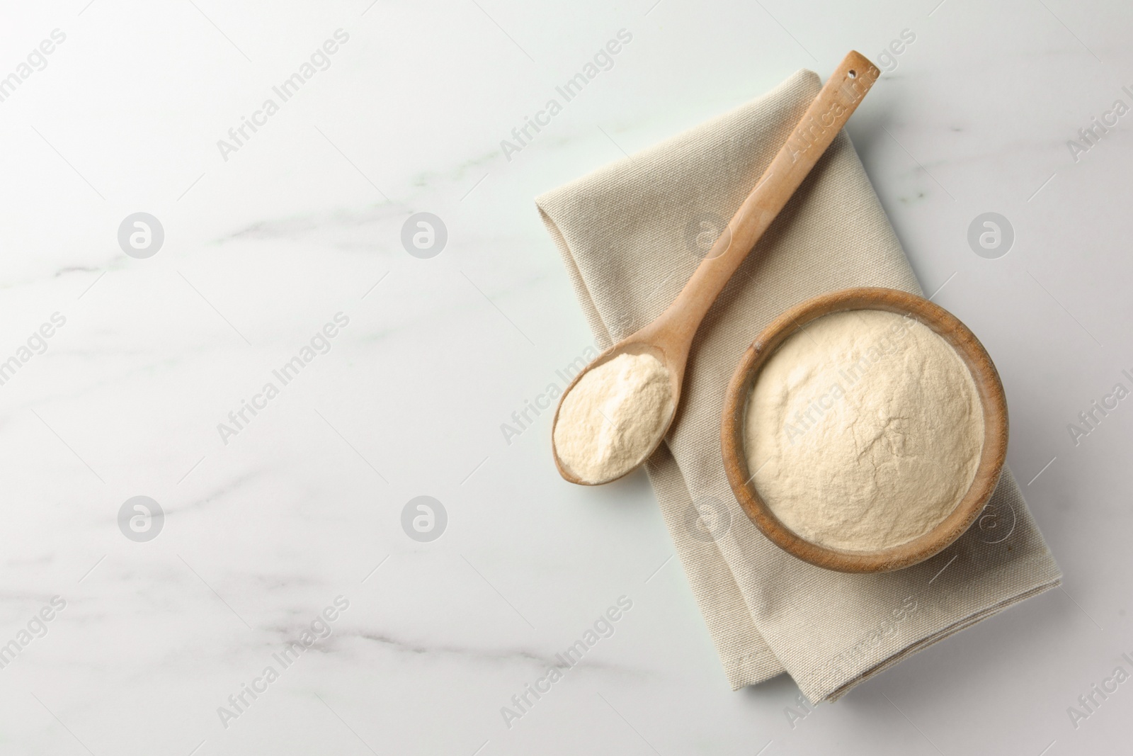 Photo of Bowl and spoon of agar-agar powder on white marble table, flat lay. Space for text