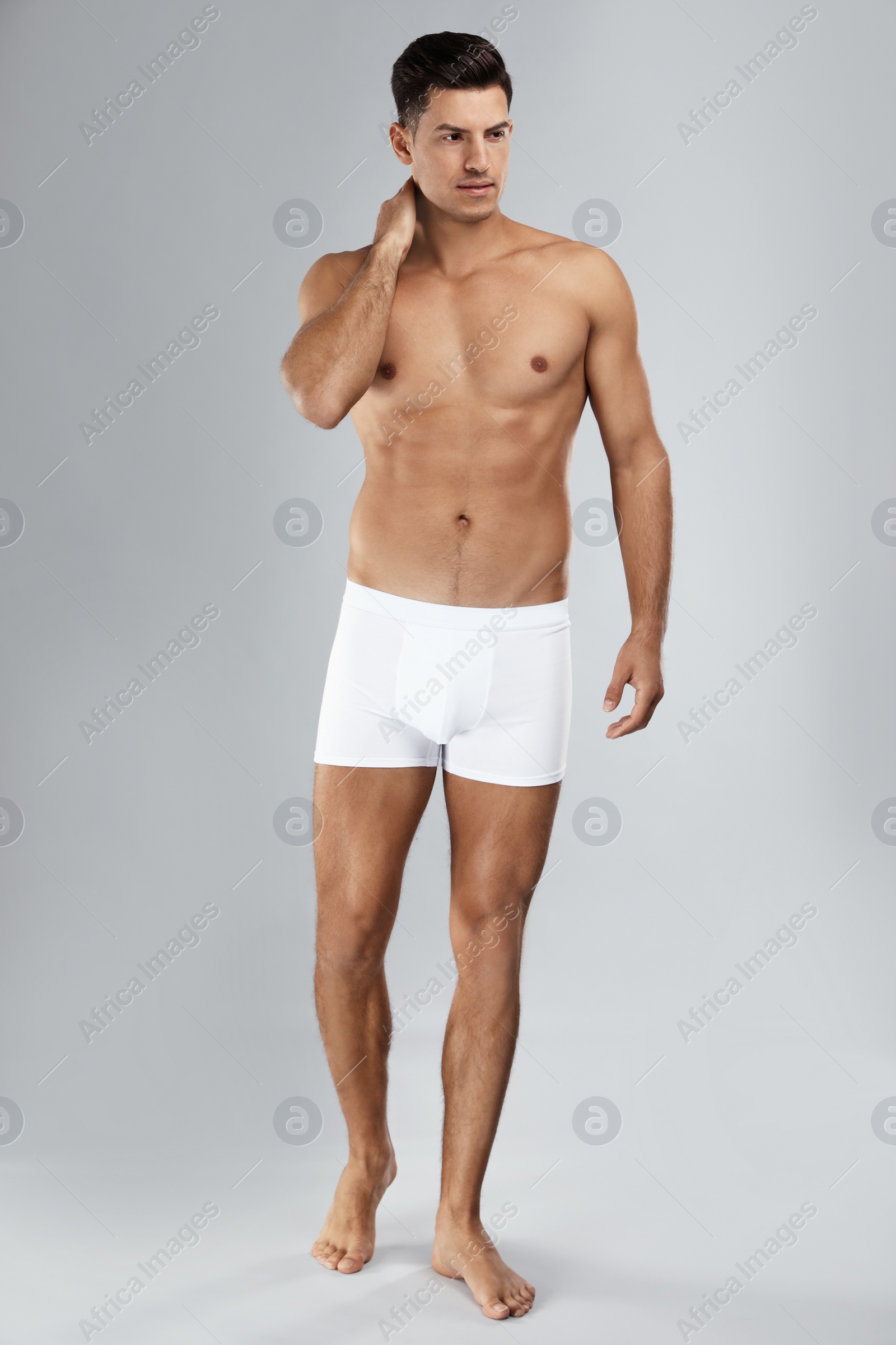 Photo of Handsome man in white underwear on light grey background