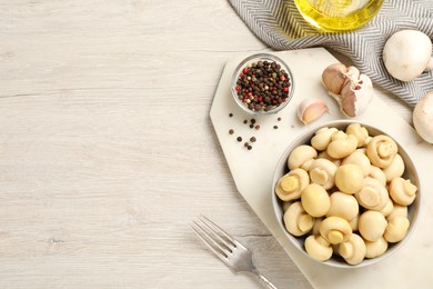 Tasty marinated mushrooms on white wooden table, flat lay. Space for text