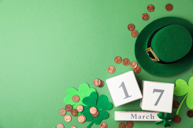 Photo of Flat lay composition with wooden block calendar on green background, space for text. St. Patrick's Day celebration