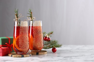 Christmas Sangria cocktail in glasses and festive decor on white marble table. Space for text