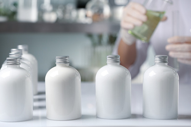 Photo of Many bottles with cosmetic product in laboratory