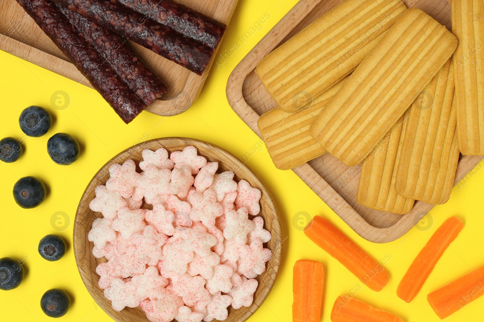 Photo of Different finger foods for baby on yellow background, flat lay