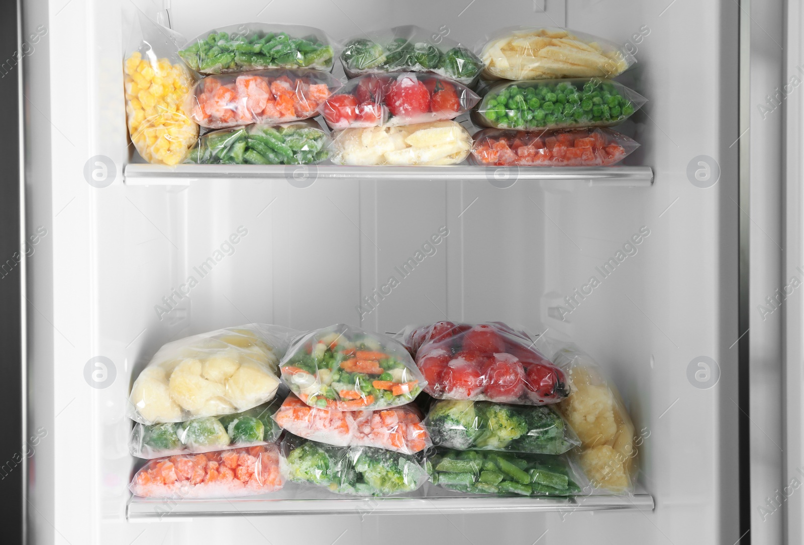 Photo of Plastic bags with different frozen vegetables in refrigerator