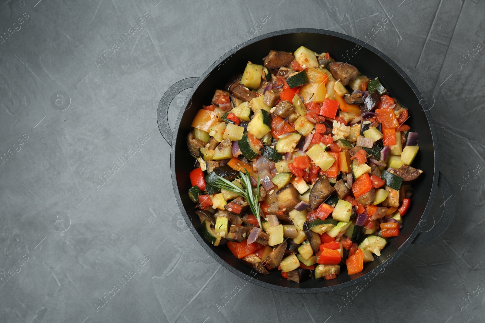 Photo of Delicious ratatouille in baking dish on grey table, top view. Space for text