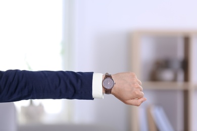 Photo of Businessman with wristwatch on blurred background, Time concept