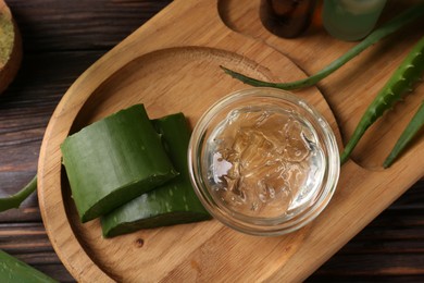 Photo of Homemade aloe gel and fresh ingredients on wooden table, top view