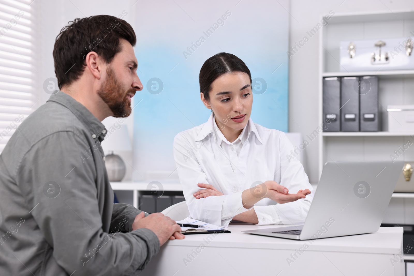 Photo of Doctor consulting patient during appointment in clinic