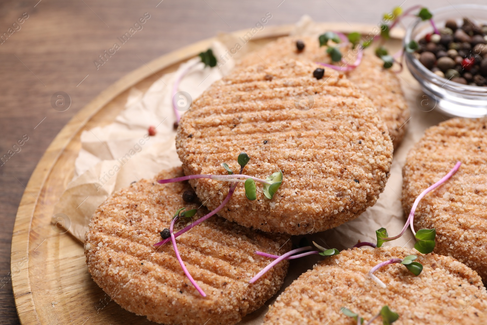 Photo of Tasty vegan cutlets with breadcrumbs on wooden board, closeup
