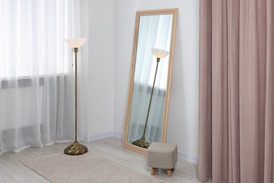 Stylish makeup room interior with long mirror and lamp