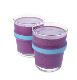 Photo of Glasses of blueberry smoothie on white background