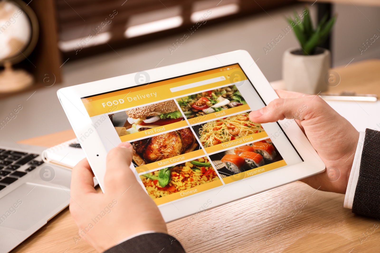 Photo of Man using tablet for ordering food online at work, closeup. Concept of delivery service