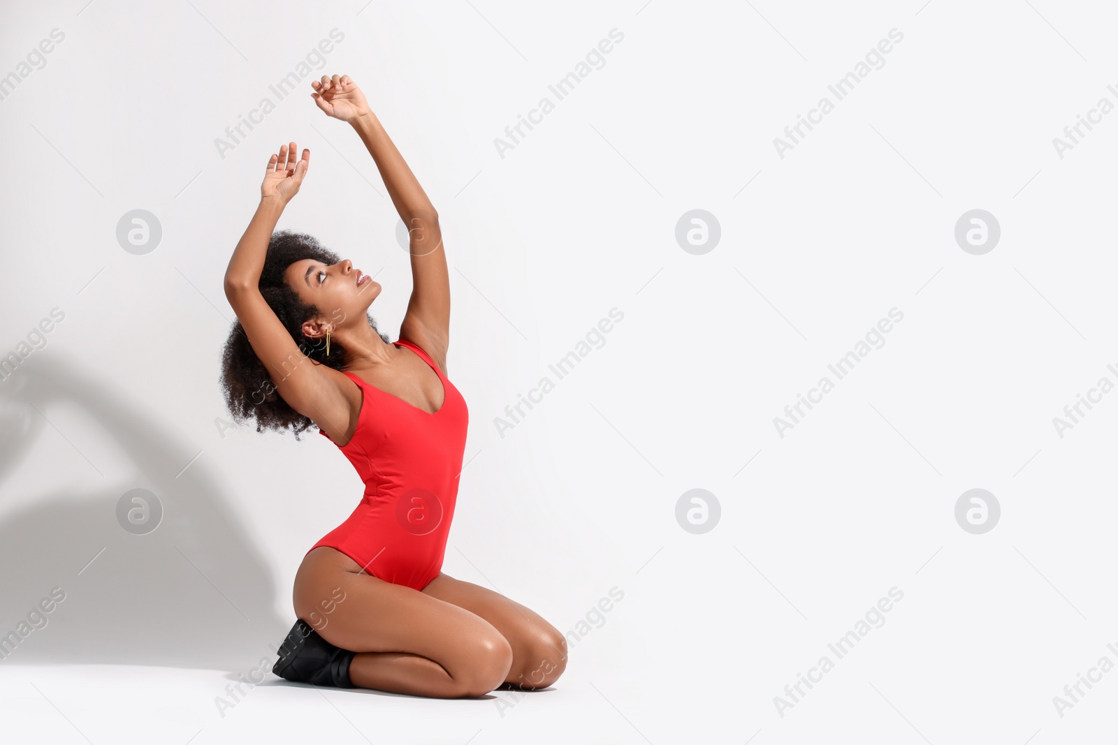 Photo of Beautiful woman in red one-piece summer swimsuit posing on white background, space for text
