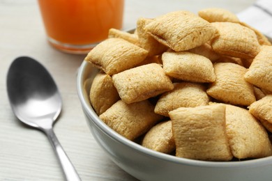 Photo of Bowl of sweet crispy corn pads and juice on white wooden table, closeup. Breakfast cereal