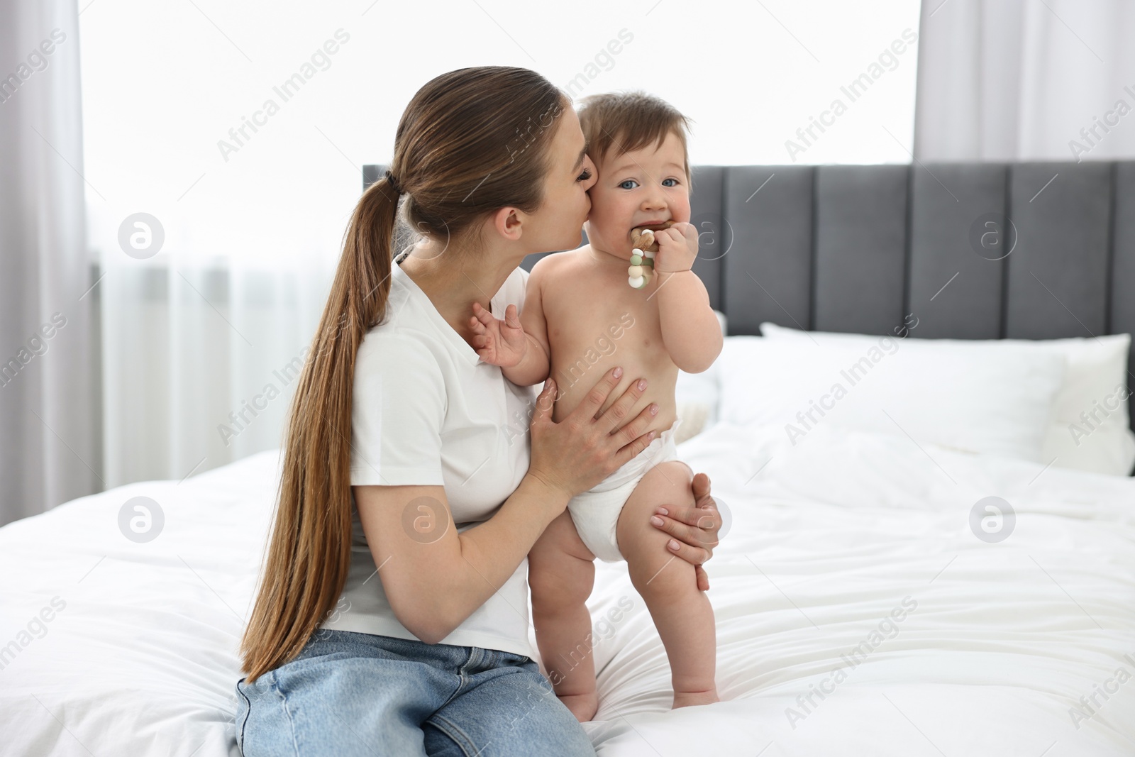 Photo of Mother kissing with her baby on bed at home