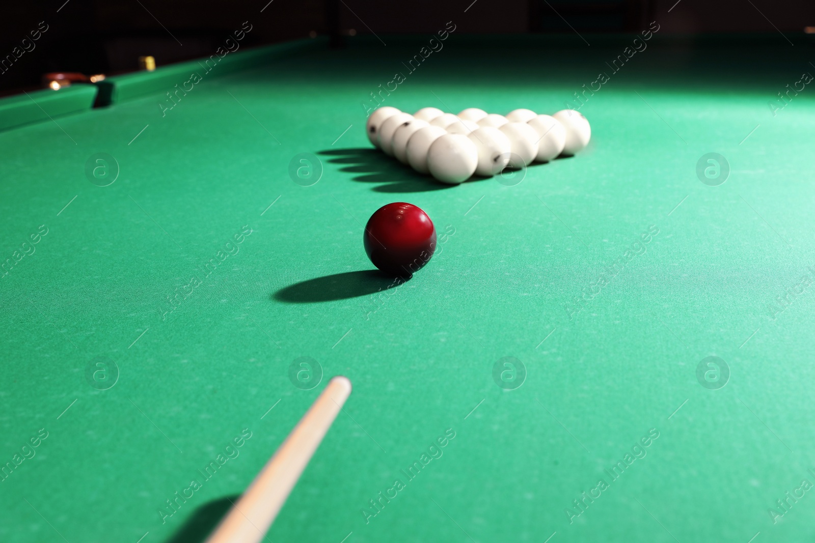 Photo of Striking ball with cue on billiard table