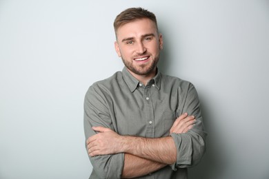 Handsome young man on light grey background