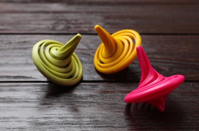 Bright spinning tops on wooden table, closeup