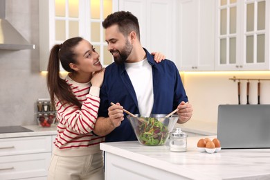 Photo of Happy lovely couple cooking together in kitchen