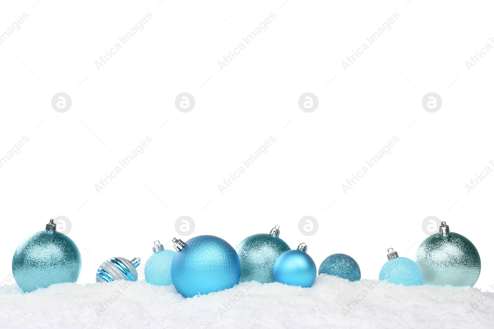 Photo of Beautiful light blue Christmas balls on snow against white background