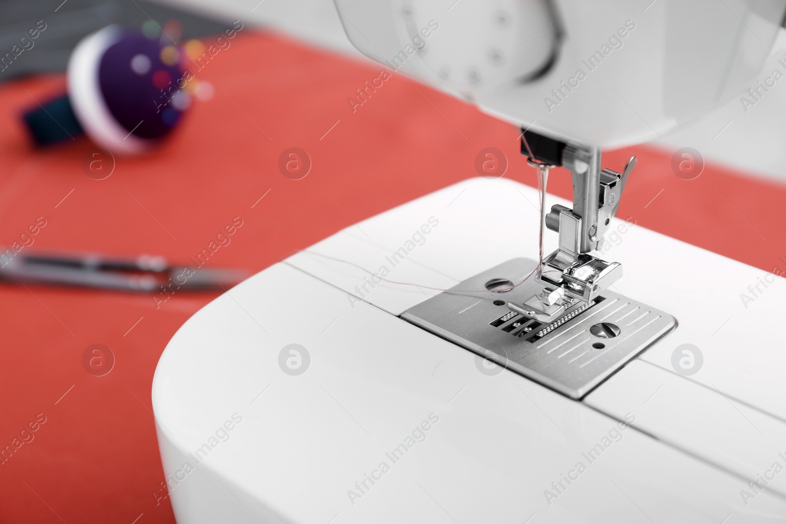 Photo of Sewing machine on table in tailor workshop, closeup