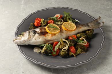 Photo of Baked fish with vegetables, rosemary and lemon on grey textured table