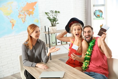 Beautiful young couple visiting travel agency office