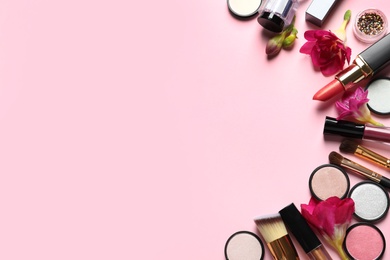 Photo of Frame made of different makeup products and flowers on color background. Space for text