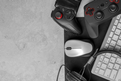Photo of Gamepads, mouse, headphones and keyboard on table
