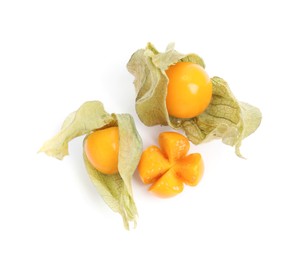 Photo of Cut and whole ripe physalis fruits with dry husk on white background, top view