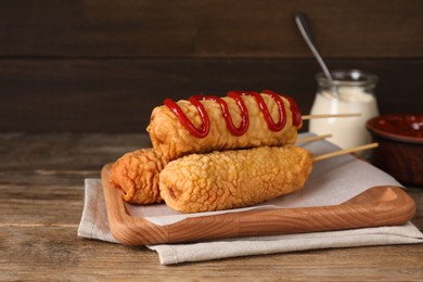 Delicious corn dogs served on wooden table