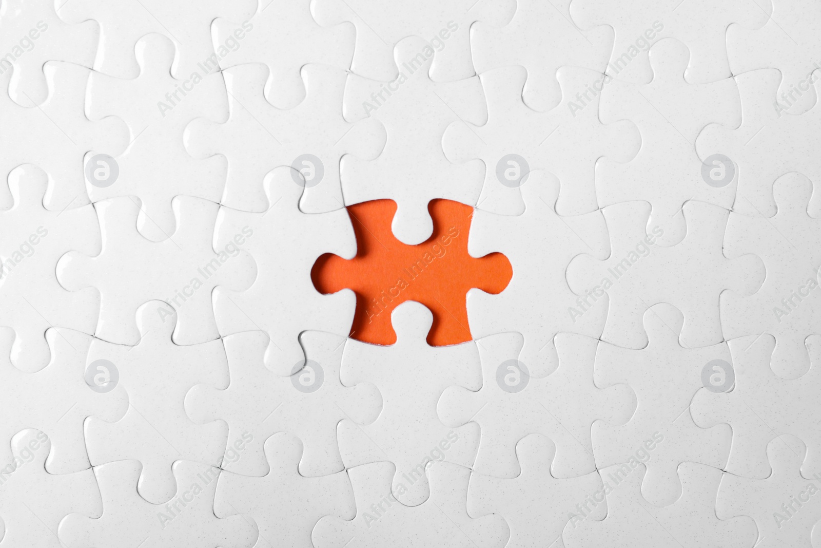 Photo of Blank white puzzle with missing piece on orange background, top view