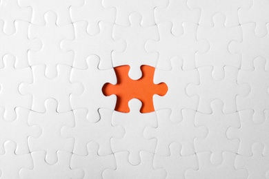 Photo of Blank white puzzle with missing piece on orange background, top view